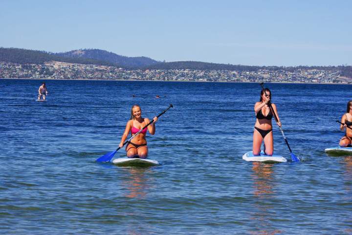 Girls on surfing paddleboards